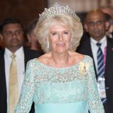 Die Greville Tiara  Sie gehört zu Königin Camillas Lieblingsstücken und ist ursprünglich gar nicht royalen Ursprungs. Die Greville Tiara ist nach ihrer früheren Besitzerin, Margaret Greville, benannt. Sie war eine bekannte Society-Lady, die sich in höchsten Kreisen bewegte. Da sie aus reichem Hause stammte, konnte sie es sich leisten, eine Juwelen-Sammlung anzuhäufen. 1921 fertigte Juwelier Boucheron in Paris eine neue Tiara aus Juwelen aus ihrer Sammlung an. 21 Jahre später starb Greville und hinterließ ihre Kollektion Queen Mum. Diese ließ die Tiara ein wenig ändern, denn die spitzenförmig angeordneten Steine in der obersten Reihe war vorher nebeneinander aufgereiht. Nach dem Tod Queen Mums 2001 ging das Diadem in den Besitz von Queen Elizabeth II. über. Sie verlieh das Schmuckstück oft an ihre Schwiegertochter Camilla. Auf dem Bild trägt die heutige Königin die Greville Tiara 2013 beim Staatsbesuch in Sri Lanka.