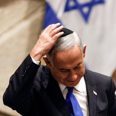 Ein älterer weißer Mann hält mit rechts seine schwarze Kippa auf dem weißen Haar