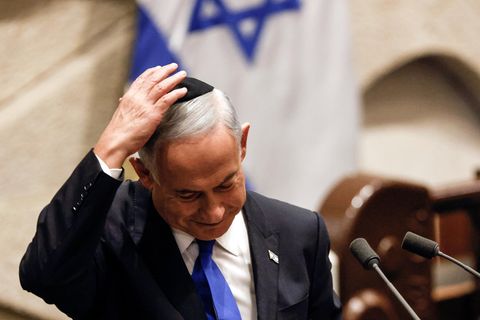 Ein älterer weißer Mann hält mit rechts seine schwarze Kippa auf dem weißen Haar