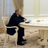 Putin und Scholz sitzen an einer langen Tafel