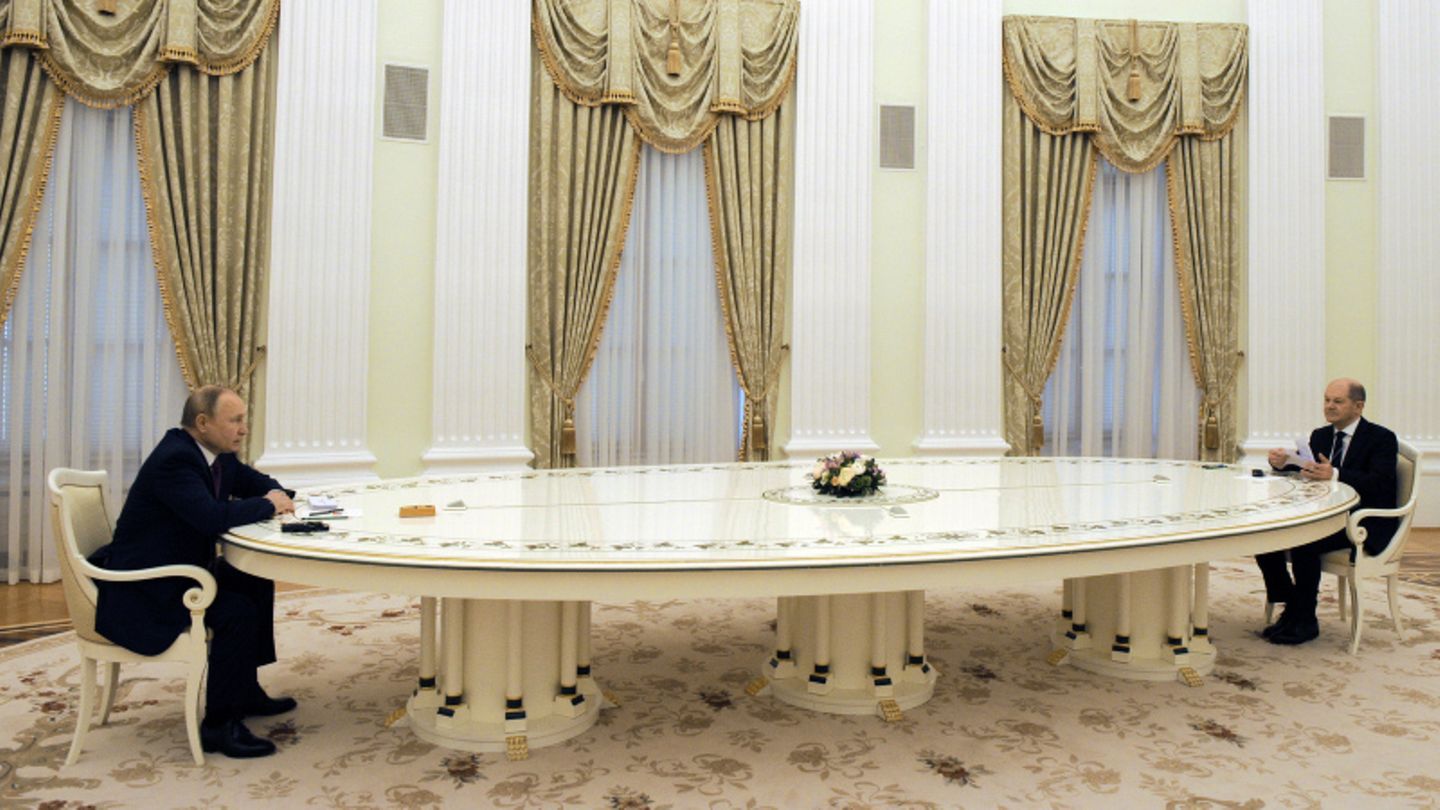 Putin und Scholz sitzen an einer langen Tafel