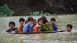 In Pakistan werden Kinder in einer Satellitenschüssel in Sicherheit gebracht
