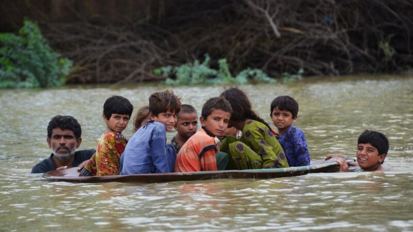 In Pakistan werden Kinder in einer Satellitenschüssel in Sicherheit gebracht