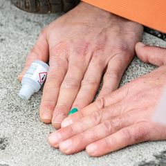 Eine Hand klebt mit Sekundenkleber an der Straße (Jahresrückblick 2022)