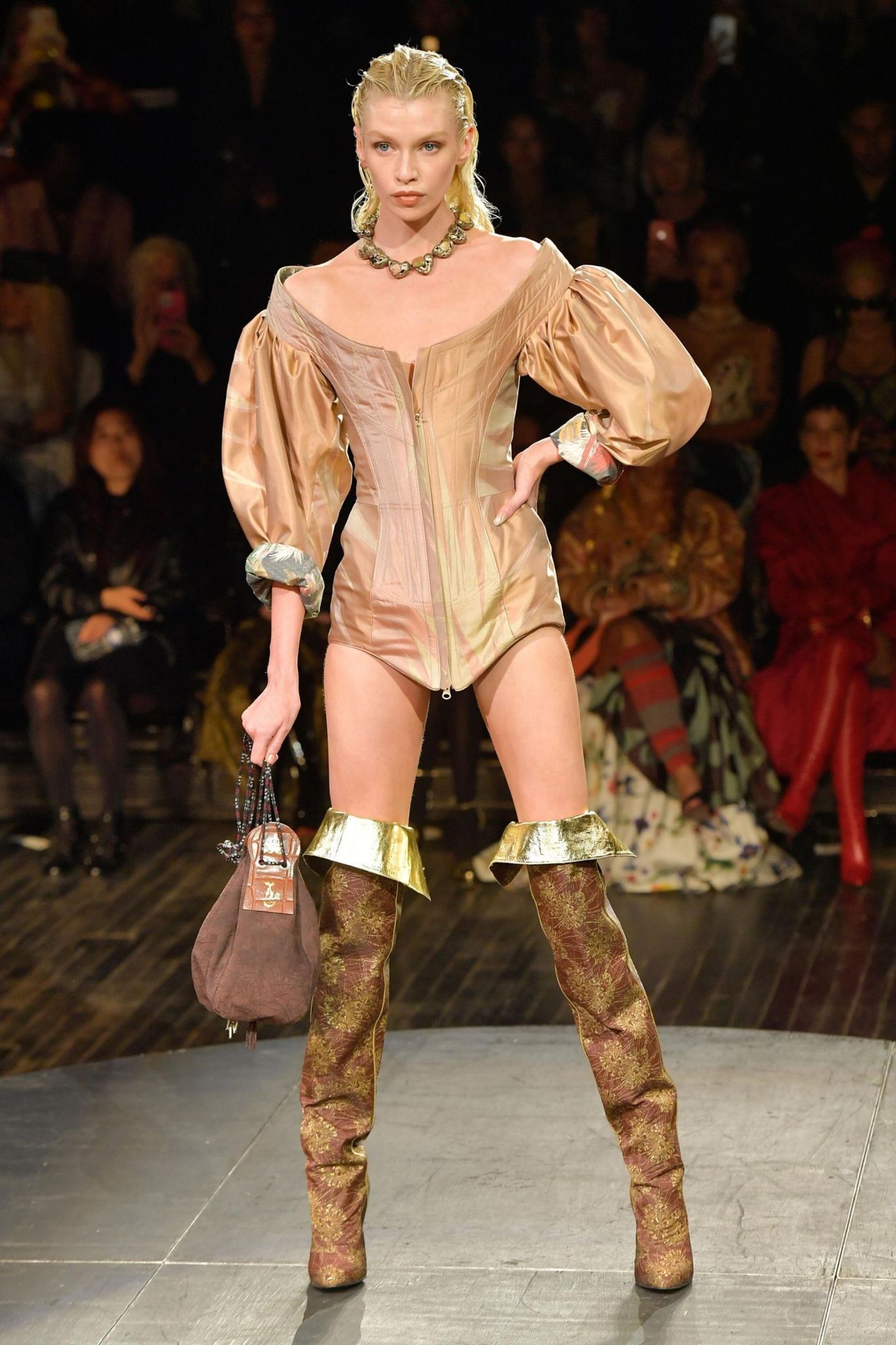 Dieses Modell führt in eine andere Epoche. Der große ovale Ausschnitt, die weit ausgestellten Ärmel, die hohen Stiefel: Die Inspiration lieferte sichtlich die Mode des 17. Jahrhunderts. 