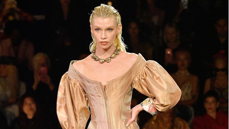 Dieses Modell führt in eine andere Epoche. Der große ovale Ausschnitt, die weit ausgestellten Ärmel, die hohen Stiefel: Die Inspiration lieferte sichtlich die Mode des 17. Jahrhunderts. 