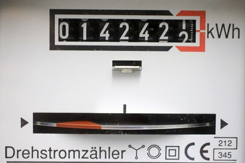 Ein Stromzähler zeigt oben 014242,1 kWh an, unten dreht sich ein silbernes Rad mit roter Markierung