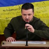 Selenskyj bei Rede mit Flagge im Hintergrund