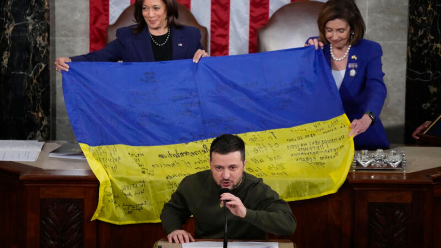 Selenskyj bei Rede mit Flagge im Hintergrund