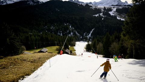 Skifahrer in einem Skigebiet ohne Schnee