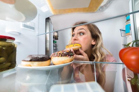 Eine Frau beißt in einen Donut