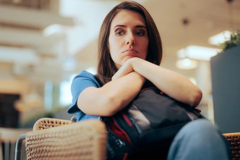 Frau wartet traurig am Flughafen