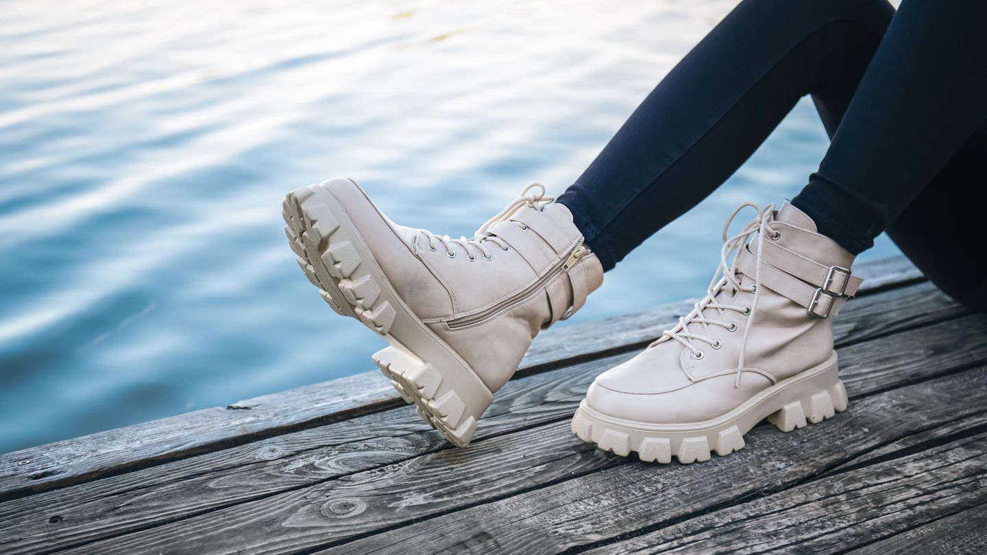 Eine Frau trägt beige Boots.