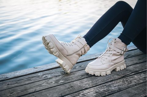 Eine Frau trägt beige Boots.