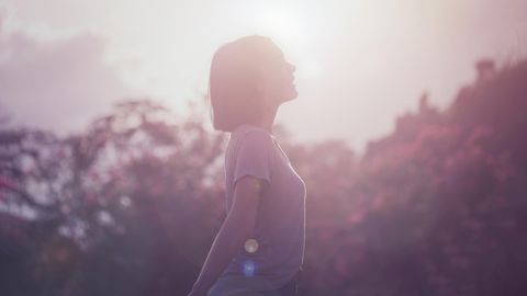 Frau steht in der Sonne um ihr Immunsystem zu stärken