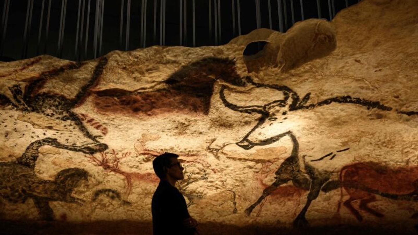 Ein Besucher vor Zeichnungen aus der Eiszeit in der Höhle von Lascaux