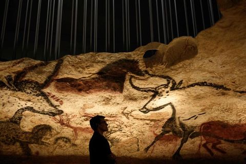 Ein Besucher vor Zeichnungen aus der Eiszeit in der Höhle von Lascaux