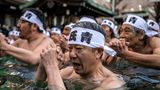 Tokio, Japan. Shinto-Gläubige des Teppozu-Inari-Schreins nehmen während eines Neujahrsrituals ein Bad in kaltem Wasser, um ihre Seele und ihren Körper zu reinigen.