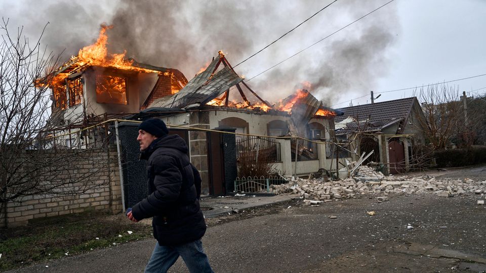 Cherson, Ukraine: Ein Anwohner läuft an einem brennenden Haus vorbei