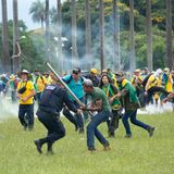 Ein Angreifer schlägt mit einer Stange auf einen Polizisten ein