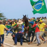 Ein Angehöriger einer berittenen Einheit ist von seinem Pferd gestürzt und wird vom Mob angegriffen