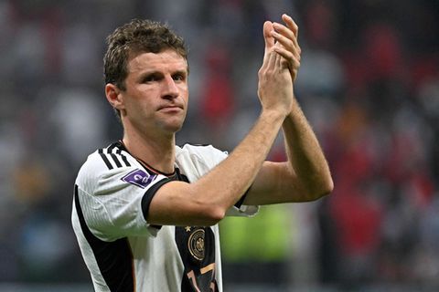 Thomas Müller, ein dunkelblonder weißer Fußballer in schwarz-weißem Trikot applaudiert mit über den Kopf erhobenen Händen