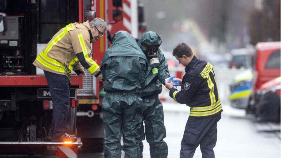 Spezialkräfte der Feuerwehr in Schutzanzügen kommen von ihrem Einsatz