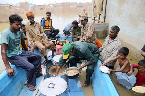 Vor der Flut gerettete Pakistaner sitzen auf einem Boot