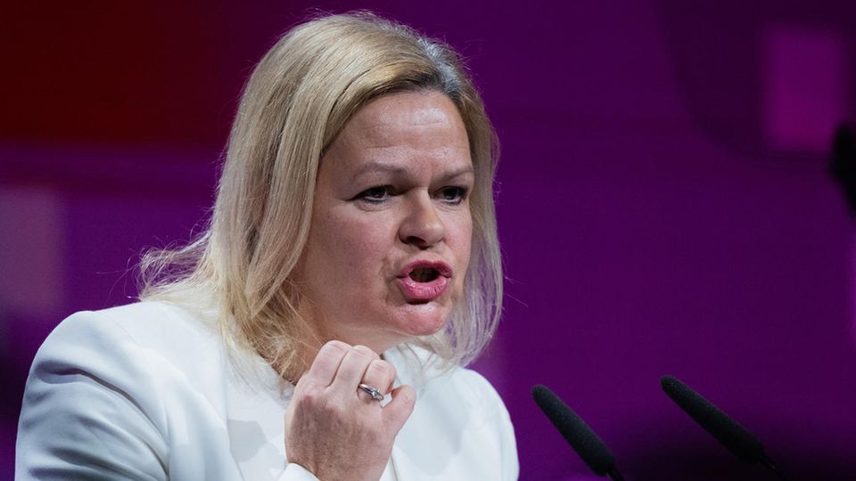Nancy Faeser Nancy Faeser gestikuliert mit der rechten Hand, während sie in weißem Blazer eine Rede hält
