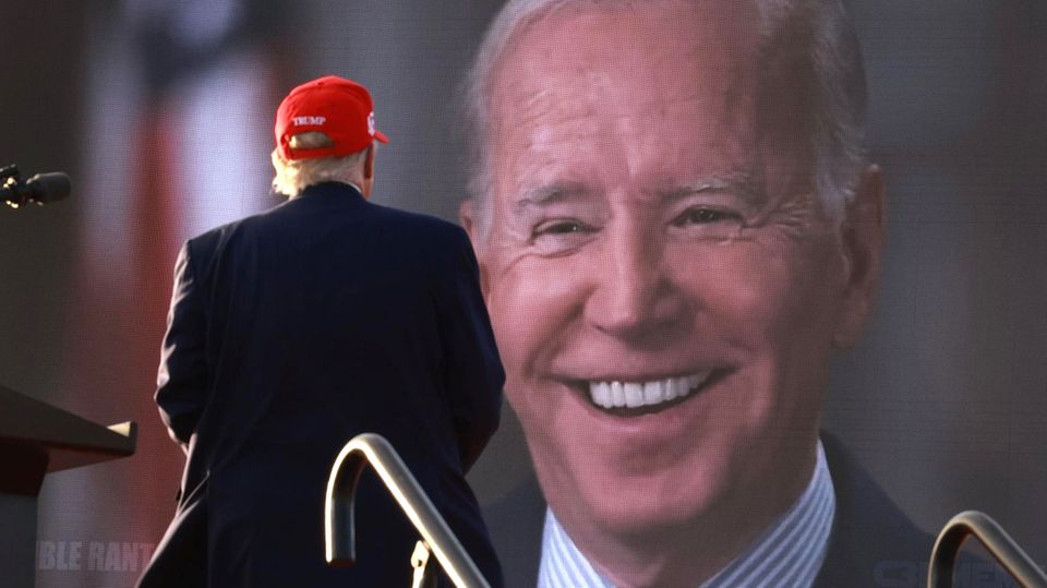 Donald Trump blickt bei einer Wahlkampfveranstaltung im November 2022 auf einen Videoscreen mit dem Gesicht von Joe Biden