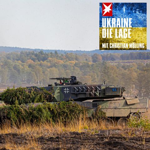 Ein Leopard 2 Panzer fährt mit Tannengrün getarnt durchs Gelände