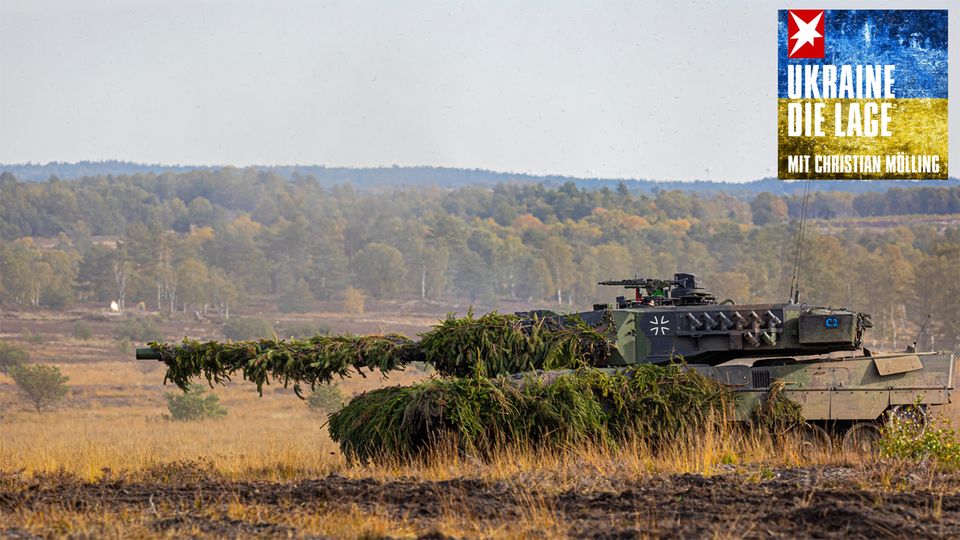 Ein Leopard 2 Panzer fährt mit Tannengrün getarnt durchs Gelände