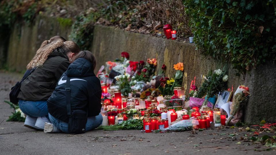 In Illerkirchberg knien Schülerinnen vor Kerzen und Blumen an der Stelle, an der zwei Mädchen angegriffen wurden