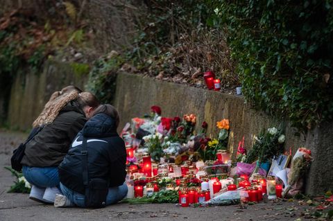 In Illerkirchberg knien Schülerinnen vor Kerzen und Blumen an der Stelle, an der zwei Mädchen angegriffen wurden