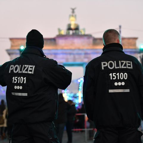 Zwei Polizeibeamten stehen in der Silvesternacht vor dem Brandenburger Tor in Berlin