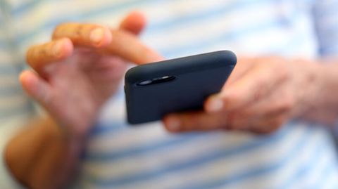 Ein Mann schreibt eine SMS. Laut Urteil müssen Arbeitnehmer in ihrer Freizeit keine Dienst-SMS beantworten