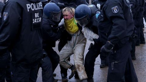 Aktivisten und Polizisten stehen sich am Rande des besetzten Braunkohleorts Lützerath direkt gegenüber