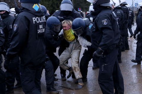 Aktivisten und Polizisten stehen sich am Rande des besetzten Braunkohleorts Lützerath direkt gegenüber