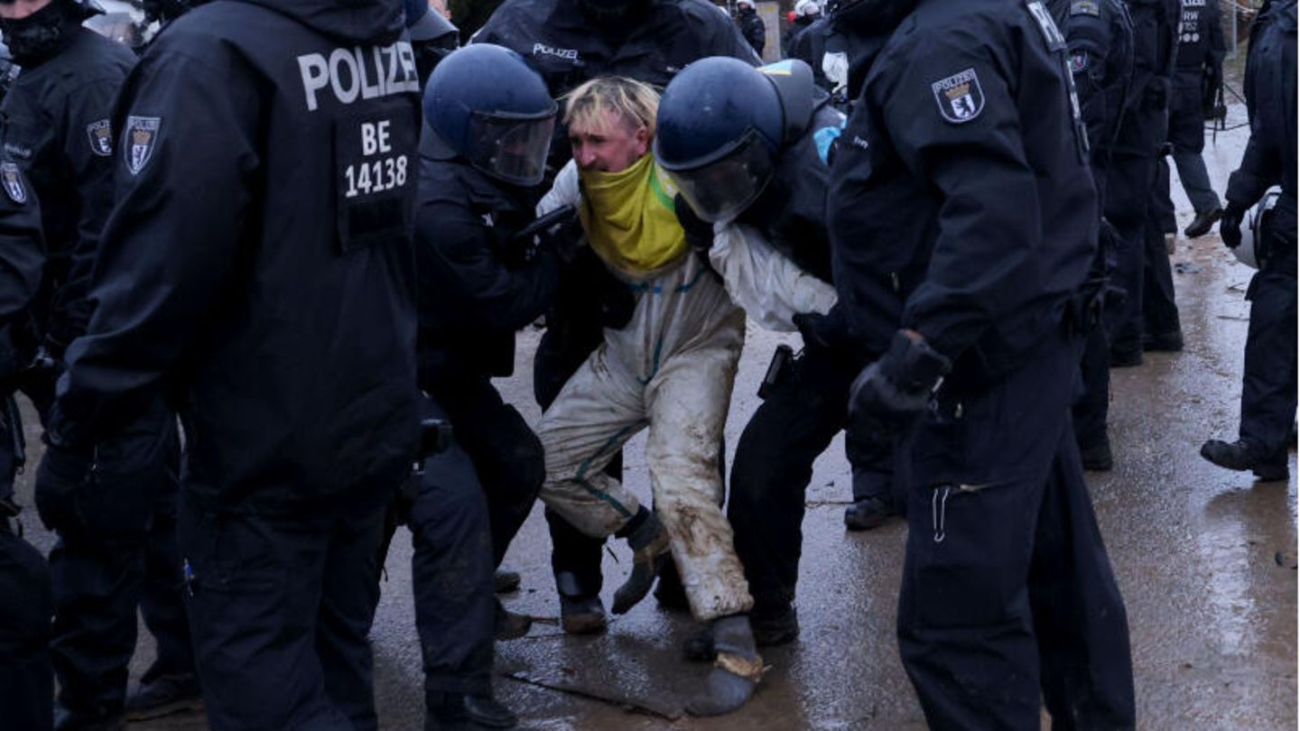 Hier wird ein junger Mann von zwei Polizisten weggezerrt