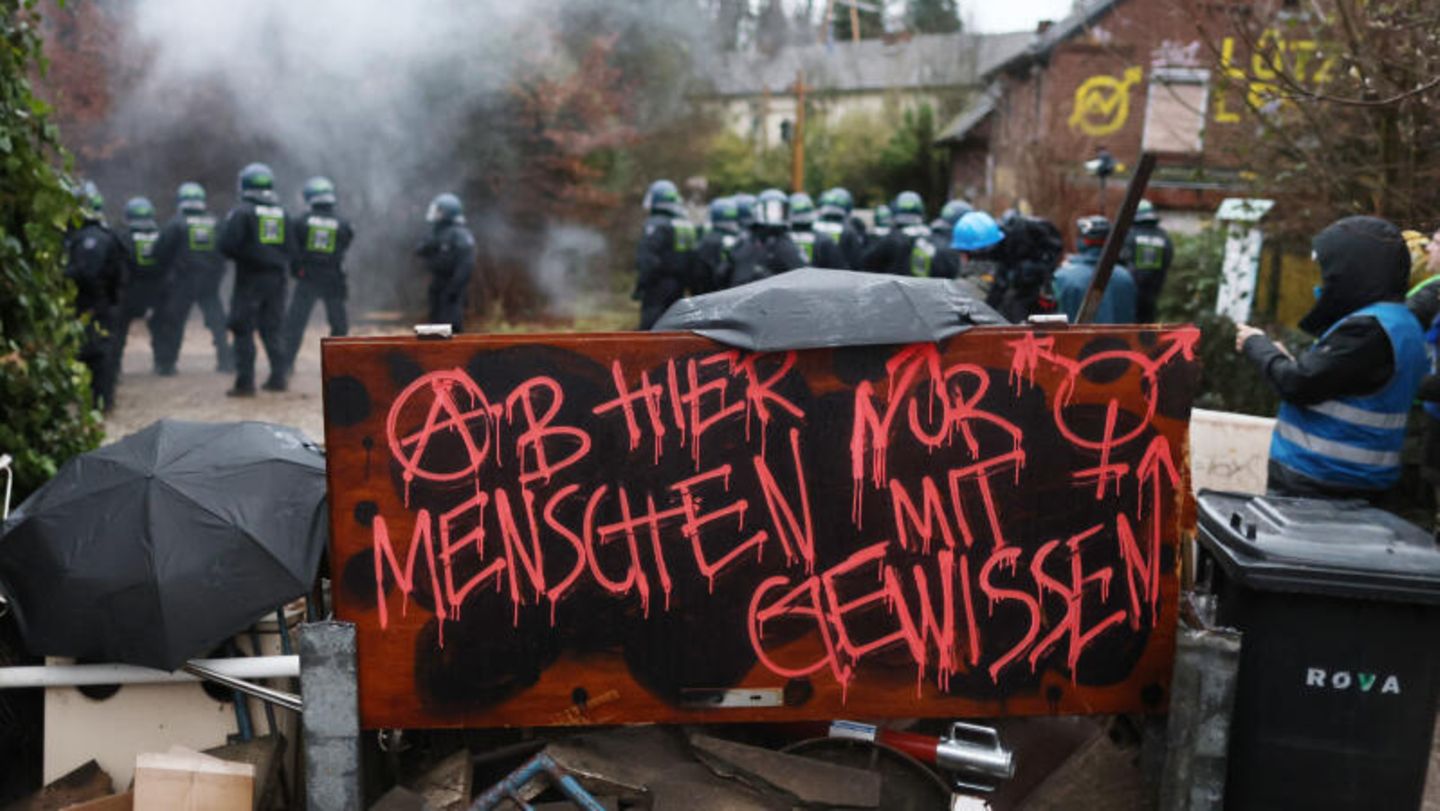"Ab hier nur Menschen mit Gewissen" steht in roter Farbe auf einem Schild der Klimaaktivisten