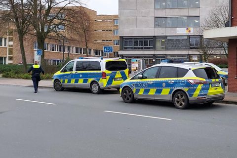 Einsatzkräfte der Polizei stehen in Ibbenbüren vor einem Berufskolleg