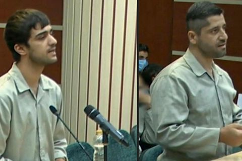 Im Iran sitzen zwei junge Männer in weißer Oberbekleidung in einem Gerichtssaal und sprechen in Mikrofone