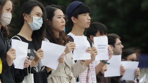 Eine Gruppe junger Demonstranten halten in Taiwan weiße Blätter in die Höhe