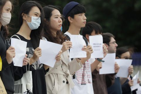 Eine Gruppe junger Demonstranten halten in Taiwan weiße Blätter in die Höhe
