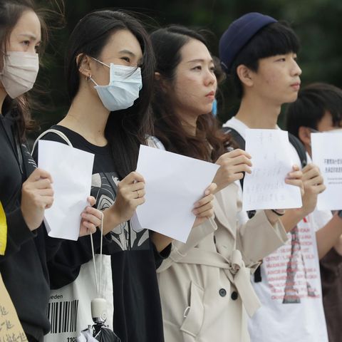 Eine Gruppe junger Demonstranten halten in Taiwan weiße Blätter in die Höhe