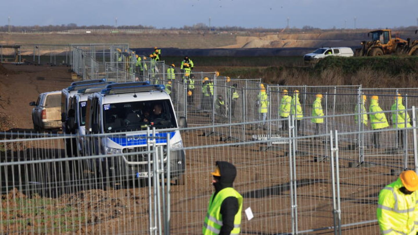 Arbeiter beginnen damit, den Braunkohleort einzuzäunen. Laut RWE soll der Zaun rund 1,5 Kilometer lang sein.