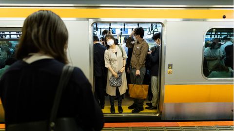Menschen stehen in einem U-Bahn Waggon in Japan
