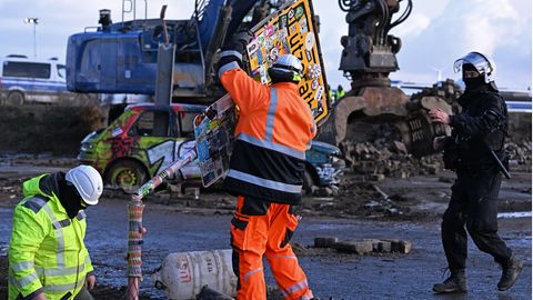 Ein Arbeiter entfernt ein Ortsschild des Dorfes Lützerat am RWE-Braunkohletagebau Garzweiler begonnen