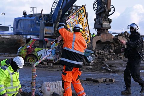 Ein Arbeiter entfernt ein Ortsschild des Dorfes Lützerat am RWE-Braunkohletagebau Garzweiler begonnen