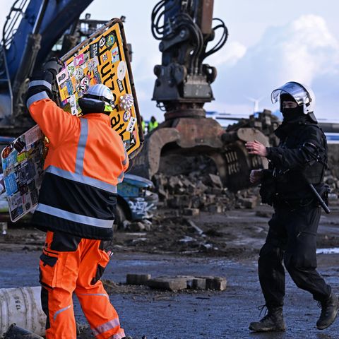 Ein Arbeiter entfernt ein Ortsschild des Dorfes Lützerat am RWE-Braunkohletagebau Garzweiler begonnen